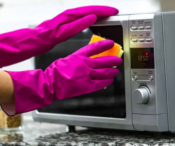 hands-rubber-gloves-cleaning-microwave-using-sponge